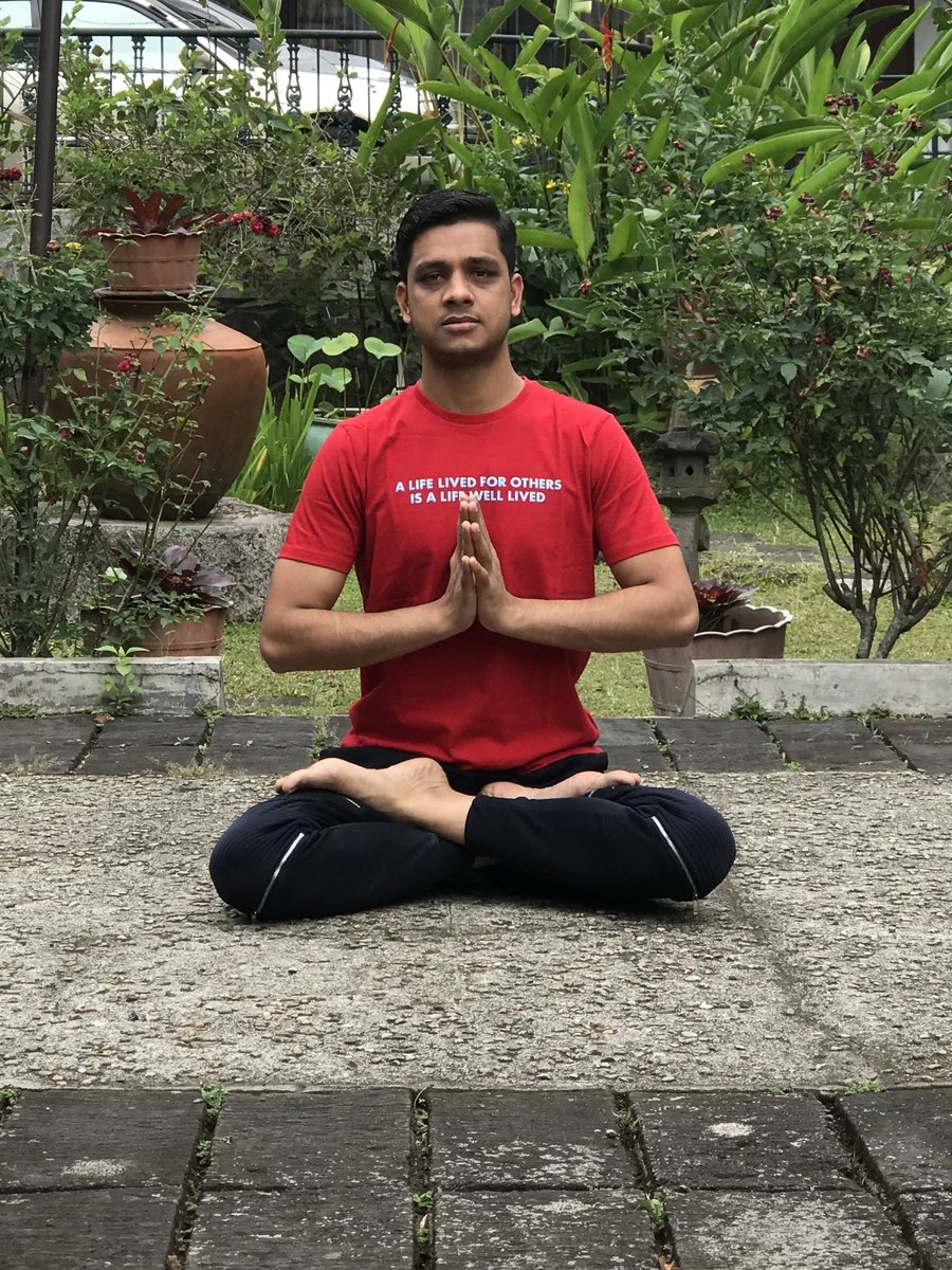 Atul Mishra seated cross-legged with his hands together at his chest